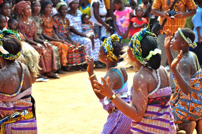 Women from Ghana dance at an event to raise community awareness about healthy behaviors.